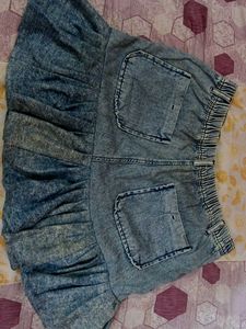 It's a Y2K style denim skirt with funky ruffles.