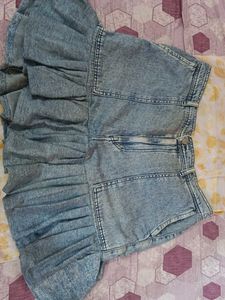 It's a Y2K style denim skirt with funky ruffles.