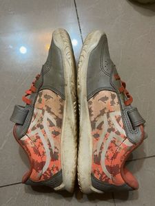 Gray sneakers with orange laces