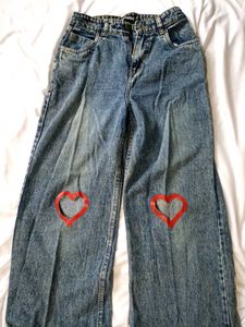 blue washed jeans with heart shape cut out .