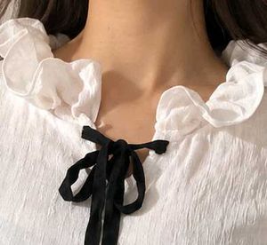 Chic White Ruffled Blouse with Black Bow