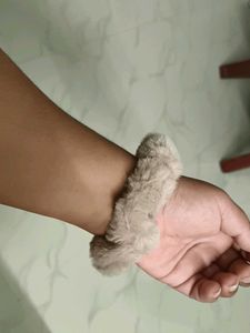 A pair of white and fur scrunchies