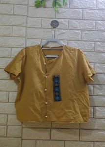 mustard-colored, short-sleeved top