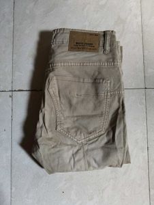 Mufti jeans in a light beige or khaki color featur