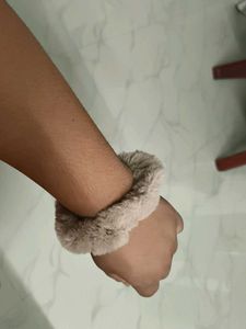 A pair of white and fur scrunchies