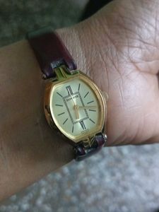 Elegant Gold Tone Watch with Burgundy Band