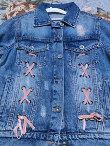 Distressed Denim Jacket with Pink Lace-Up Detail