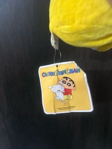 Shin-chan wearing a red shirt and yellow shorts