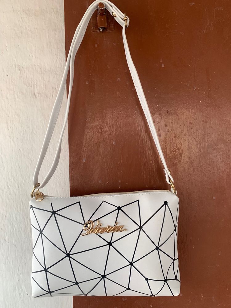 Brand new Ladies White sling bag in black design.