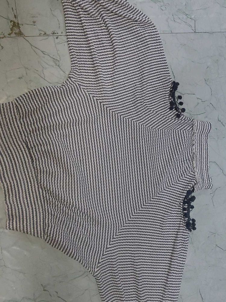 stripped knitted top with pom-poms on sleeve