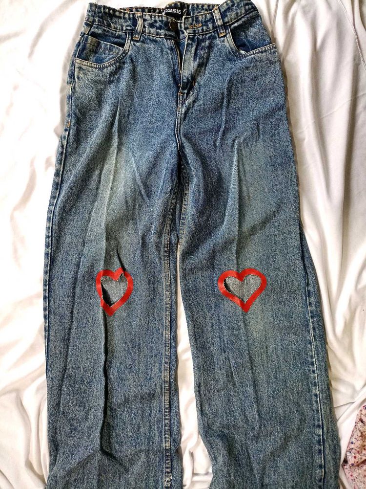 blue washed jeans with heart shape cut out .