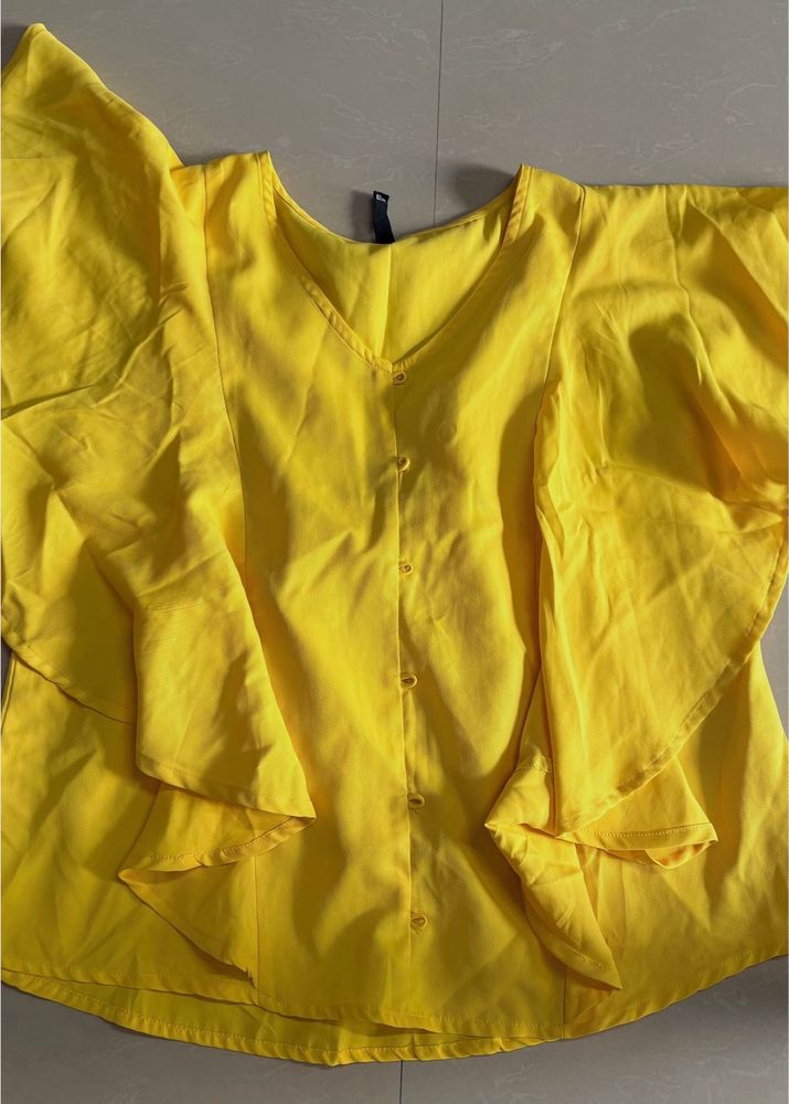 yellow styled top. flare on sleeves and neck