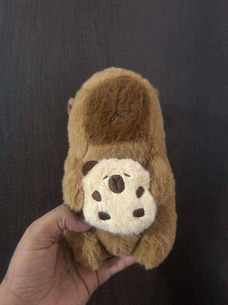 Capybara plush toy holding a small bread or toast