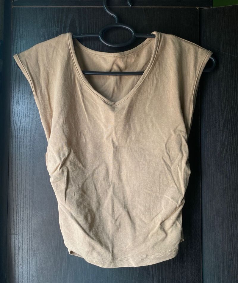 Beige/tan sleeveless top with a V-neck