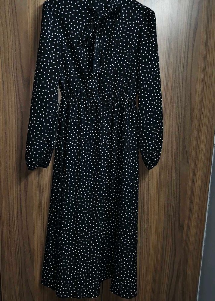 The dress is designed with a bow tie neck