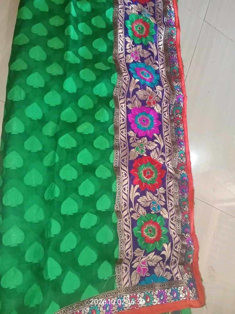 a printed saree with net in green color which look