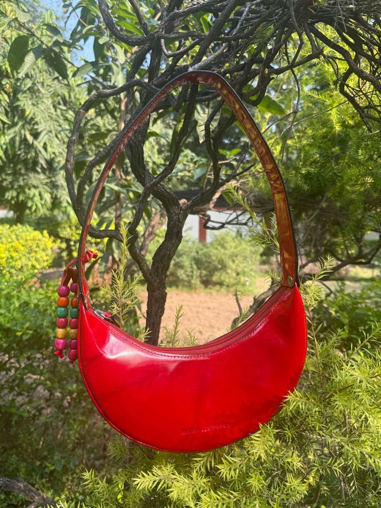 Shop Mistry Red Patent moon bag