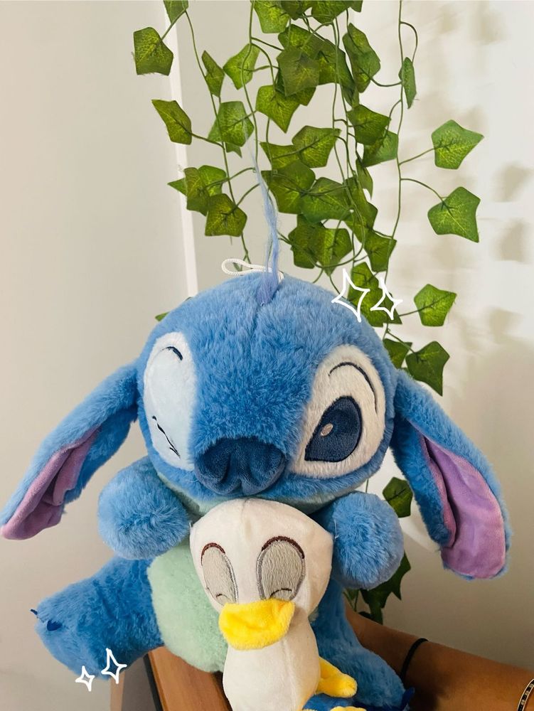 Stitch holding a duck plushie!
