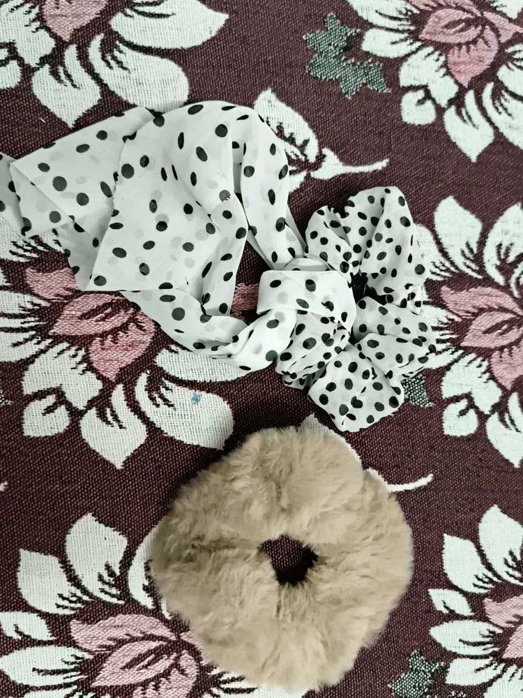 A pair of white and fur scrunchies