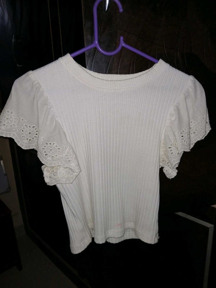 White ribbed crop top with flare sleeves.