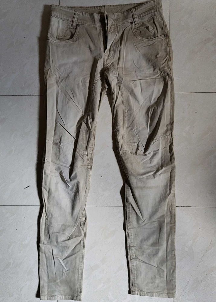 Mufti jeans in a light beige or khaki color featur
