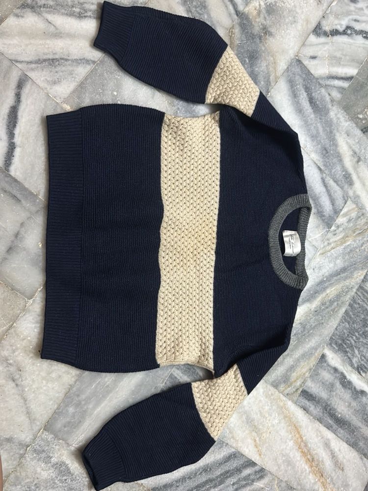 a knit sweater in shades of navy blue and beige