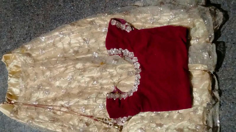 The maroon  lehenga   with golden colour net gown